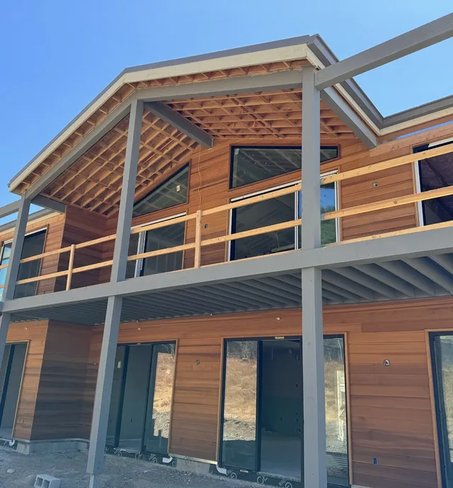 Exterior framing near completion with window and door installation shown